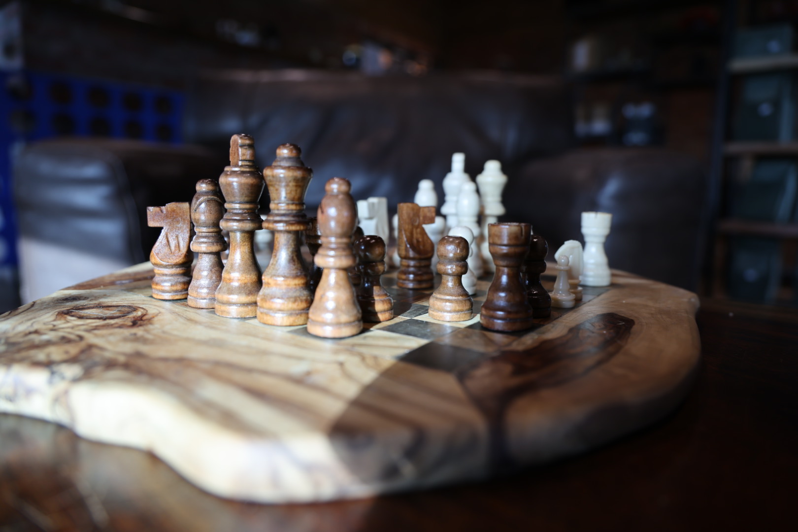 Wooden chess board mid-game on a live-edge table