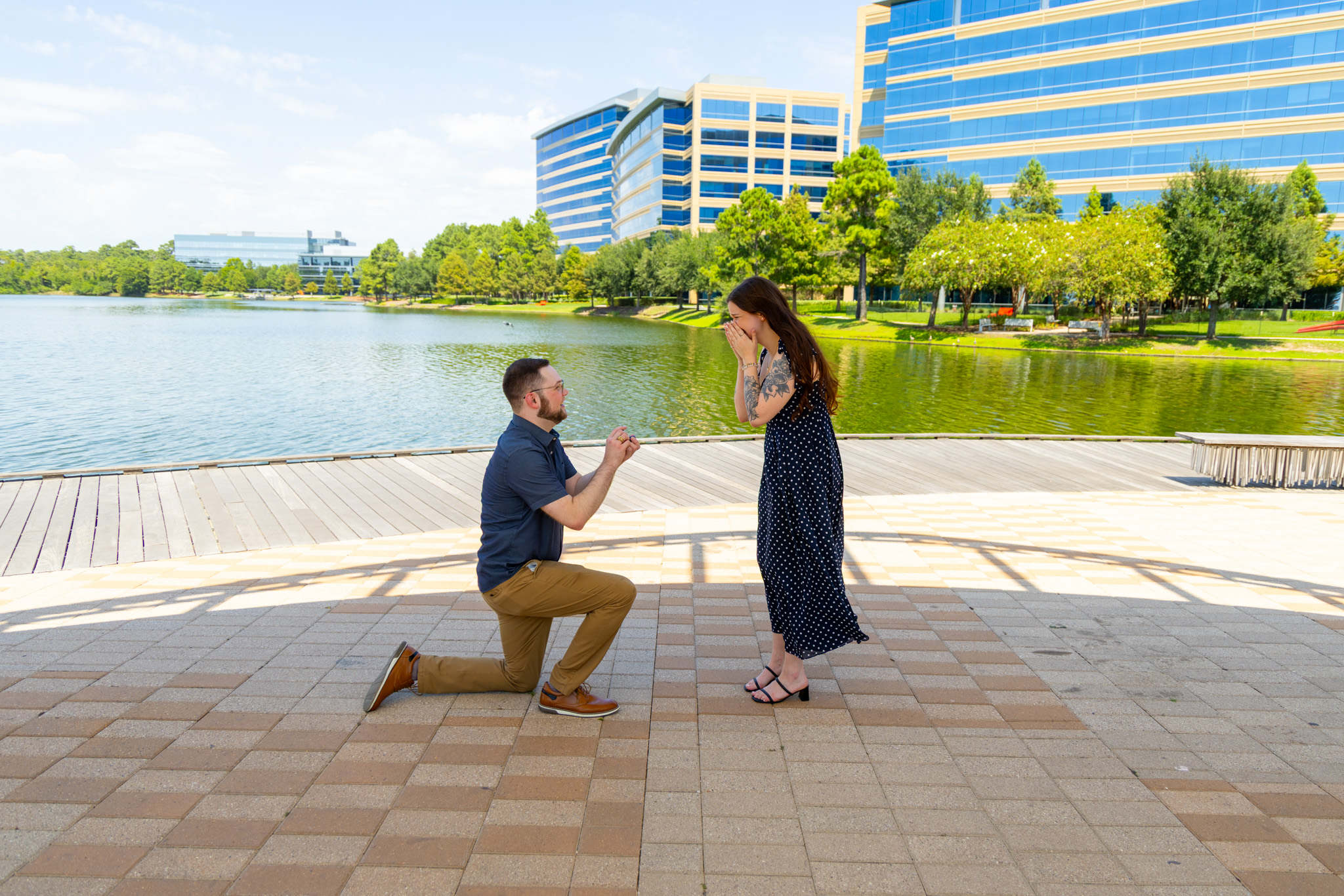 Brandon proposing to Emily beside the lake and city skyline